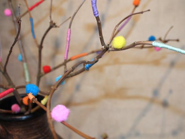 Decorating branches with ribbons and pom-poms